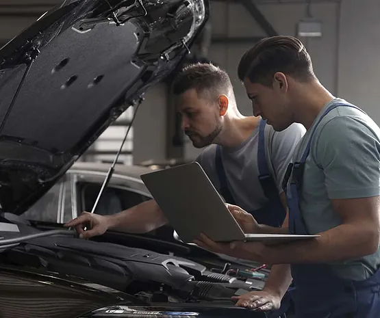 Hombres revisando vehículo con computador